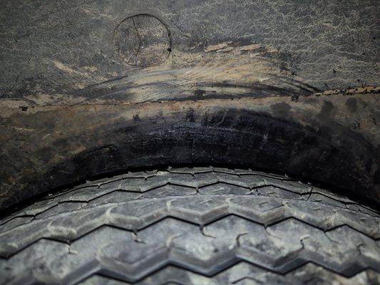 This is a new tire with original size on it. The background is where the bigger tire rubbed against my axel causing it to just melt .