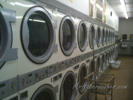 The row of dryers, with a laundry cart in view.