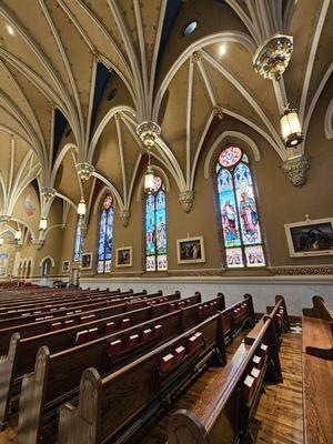 The stained glass windows and pews of the Basilica of Saint Andrew.