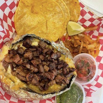 Grilled Baked Potato with carne asada, tortillas, grilled onions and salsas.