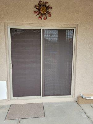 Sliding patio door and fixed panel installed with sun screen