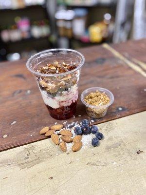 Yogurt, mixed berries, açaí powder, almonds, blueberries, raw almonds and coconut. Top it with our non GMO toffee almond granola.