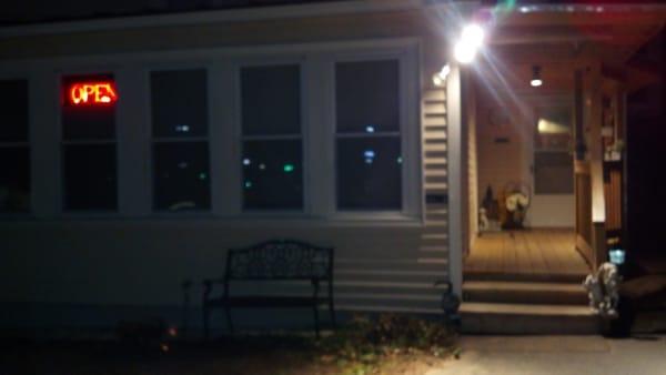 Look for a 'Open' sign in a house window (if it's dark), the sign with the name isn't lit up