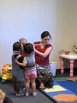 Toddlers enjoy a flute experience with their teacher.