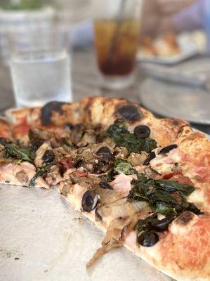 Pizza with ham, olives, onions, mushrooms, spinach (and zucchini I believe).