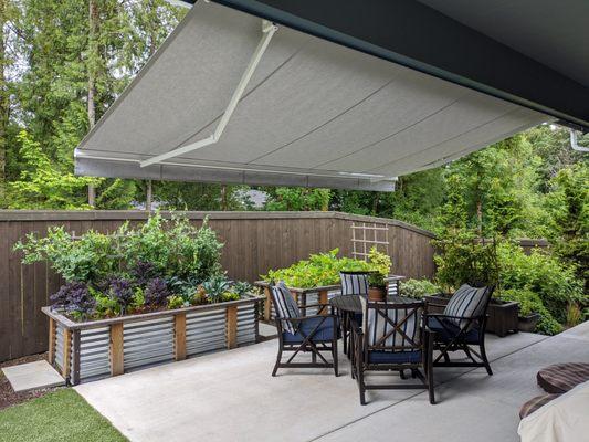 Retractable patio awning. Provides sun protection as well as mild rain protection. Rolled in with the touch of a button