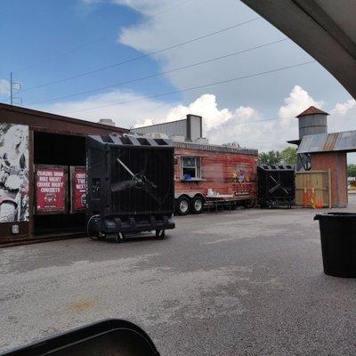 The view of the food truck and fan taken from one of the covered tables.