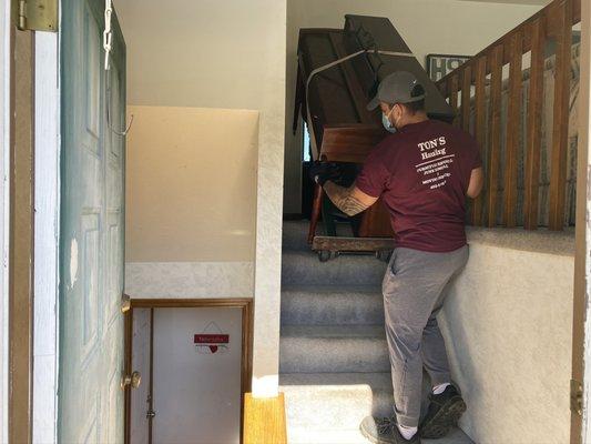 Removing a upright spinet piano from a split level home in Omaha Nebraska.