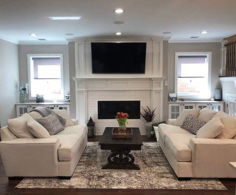 Custom designed fireplace surround and overmantle with picture framed windows and storage cabinets.