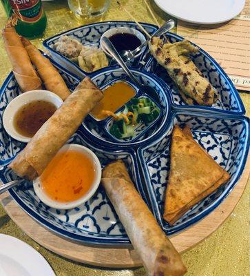 Sampler for two-spring roll, chicken satay, curry fried, dumplings, and shrimp in a blanket