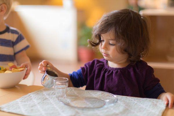 Toddler student pouring herself water