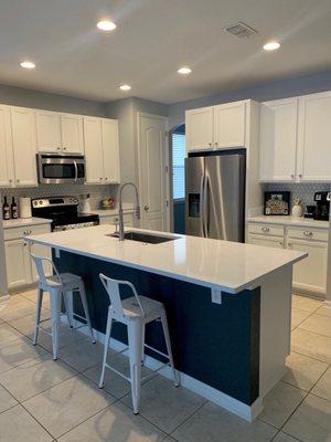 We painted the cabinets, But they leveled our island, did all the quartz counter tops, sink install, faucet, and back splash. Amazing work!