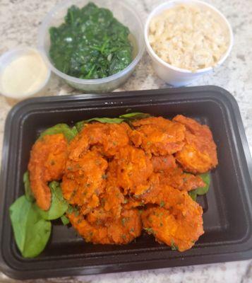 Buffalo shrimp with sautéed spinach and seafood salad.