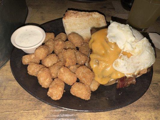 The roost burger with tots and a side of ranch.