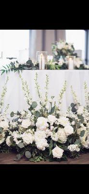 Sweetheart table with reused grounded arch ceremony florals