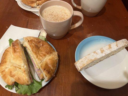 Ham, egg, cheese with lettuce and tomato on a croissant. Pumpkin spice latte. Lemon almond biscotti.