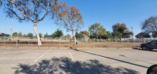 Parking lot but you see no grass and entirely covered with a fence around