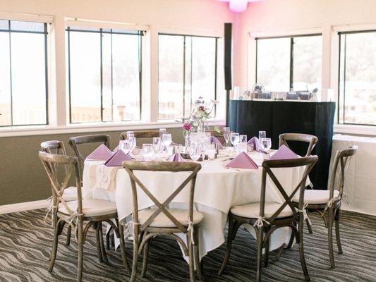 DJ booth is set off in the corner of the room. Lavender pin light in the corner, small and discreet.