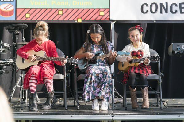 Three girls with guitar and ukulele.