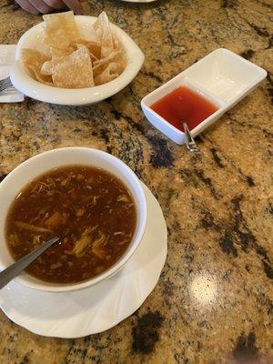 hot and sour soup that comes with lunch special. top of photo is the free chips that come to table