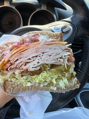 Turkey with lettuce, tomato, cheese, mayo, and hot cherry peppers on wheat bread