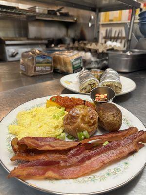 Scrambled eggs and bacon with a slide of polenta, baked potato, and a baked apple