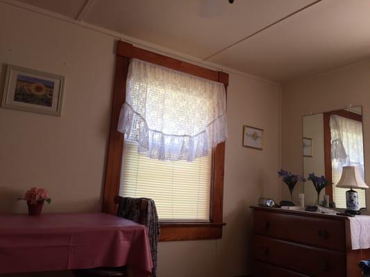 One of two windows (the other has a great AC unit) with table and mirrored vanity (with drawers)