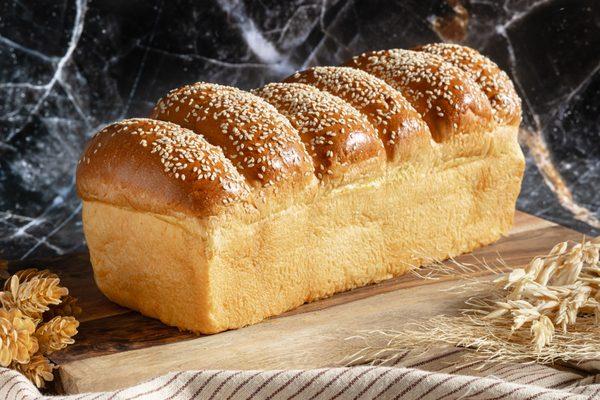 Soft, golden, and topped with sesame seeds, this fluffy egg bread (challah loaf) offers a rich, buttery taste that's perfect for any meal.