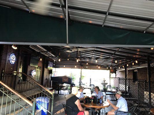 Covered patio on the side of the building. Heaters against the wall and fans overhead.