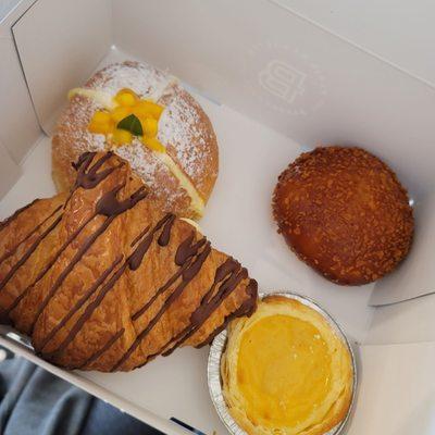 Top left, clockwise: Mango cream brioche, crab croquette, pastel de nata, chocolate croissant