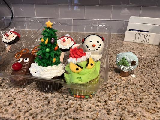 Reindeer cookie, Christmas tree cupcake, Santa Oreo, grinch cupcake, snowman hot cocoa bomb, and Oreo snow globe!