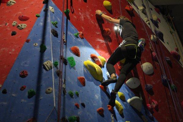 Member climbing top-rope with a headlamp during our Lights Out Event.