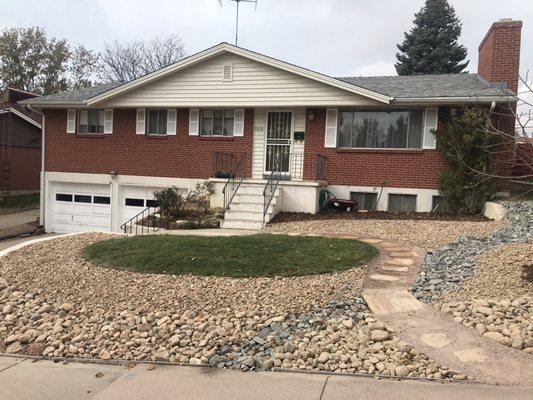 After picture of our landscape redo with new sod installed, rock border, dry rock stream bed and pathway.