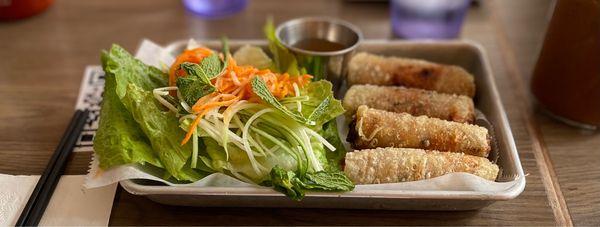 SPRING ROLLS.  Minced Pork & Shrimp Filling  Served with Fish Sauce (Nuoc Cham)  Romaine, Pickled Veg. and Mint