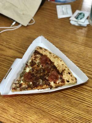 Three meat pizza slice.