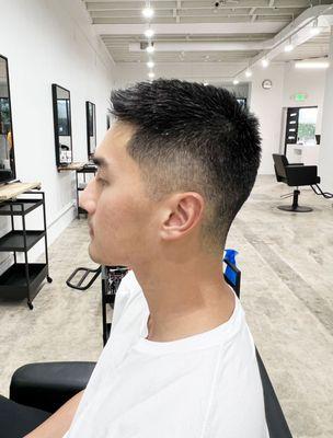 Sharp buzz cut with a mid fade, blending seamlessly for a clean and polished look. By Yuna