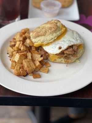 Biscuit with Pulled Pork, egg and cheese. Home fries on the side