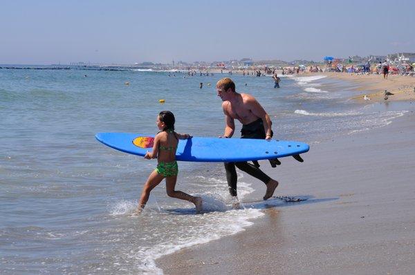 Instructor Bryan brings a young student out for a few waves on a hot summer day.