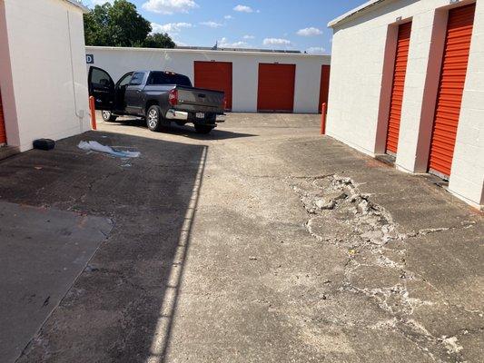 Flat tire and truck on rim with jagged concrete on right and shattered plate glass on left.