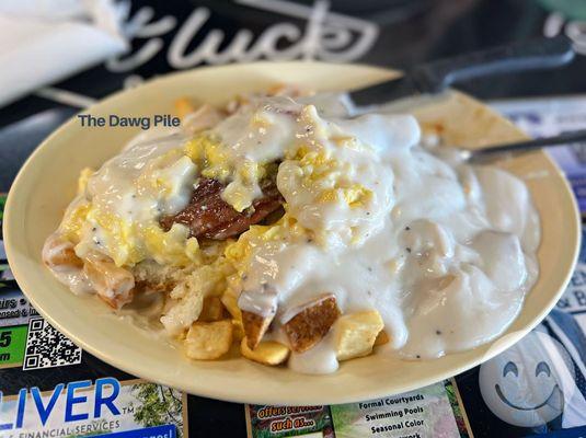 2 eggs, city ham, bacon, sausage, home fries on an open biscuit, all covered in gravy.