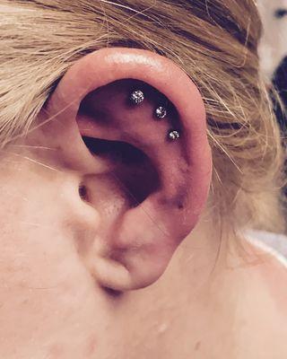 Cartilage piercing using flat back jewelry for comfort and faster healing.