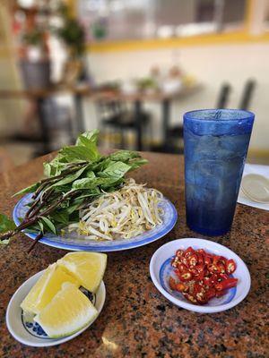 Condiments for pho and a glass of iced barley tea