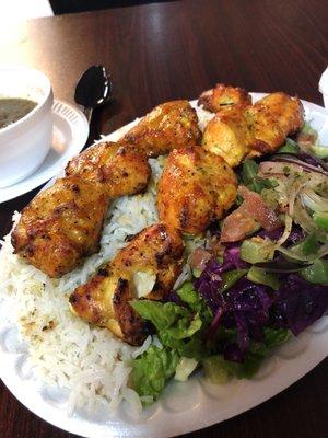 Chicken kebab with rice and salad.