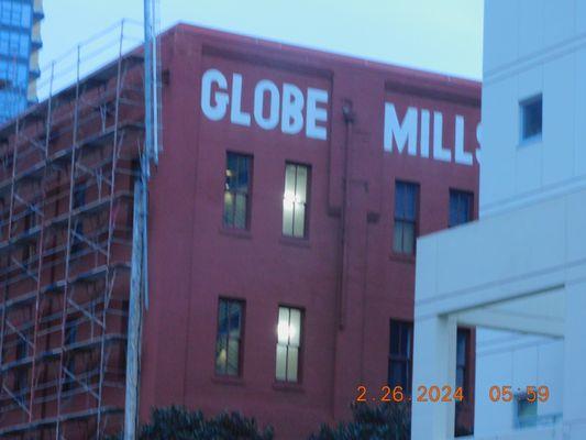 Globe Mills one of the many building that you can find as you take the trolley, and the lights are on inside.