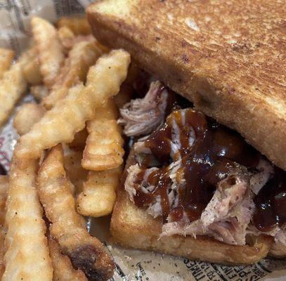 Lunch serving of bbq chicken on garlic bread with fries