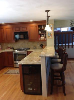 Cherry stained cabinets, stainless steel appliances, diamond stone tile backsplash, hardwood floors