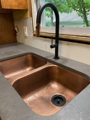 Honed quartz countertop, hammered copper double sink and touch faucet.