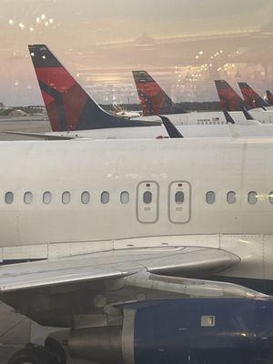 Delta planes lined up against a sunset sky