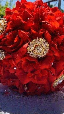 Beautiful Bridal bouquets made with red roses, diamonds, crystal, gold brooches and a gold blinded handle.