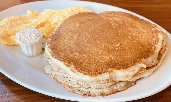 Scrambled eggs with fluffy light pancakes